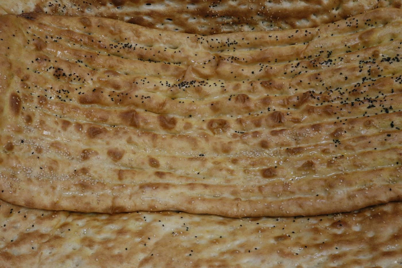 Long sheets of Afghan naan, golden and dotted with seeds